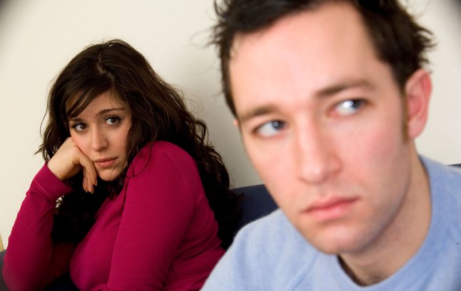 Young couple on a sofa after a row argument