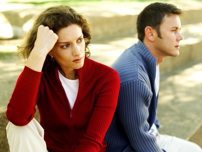 Young Couple Seated Back To Back