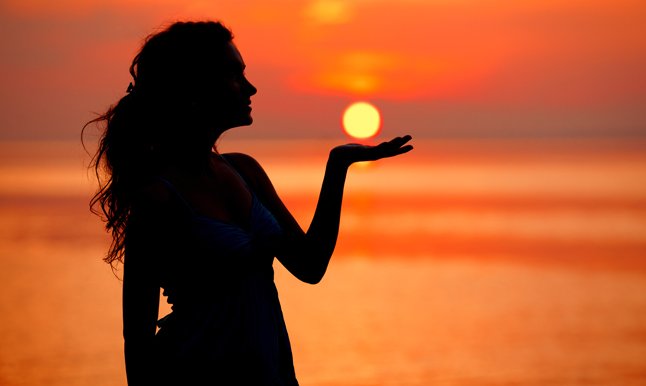 Happy free Woman enjoying in Sea Sunset. Silhouetted against the