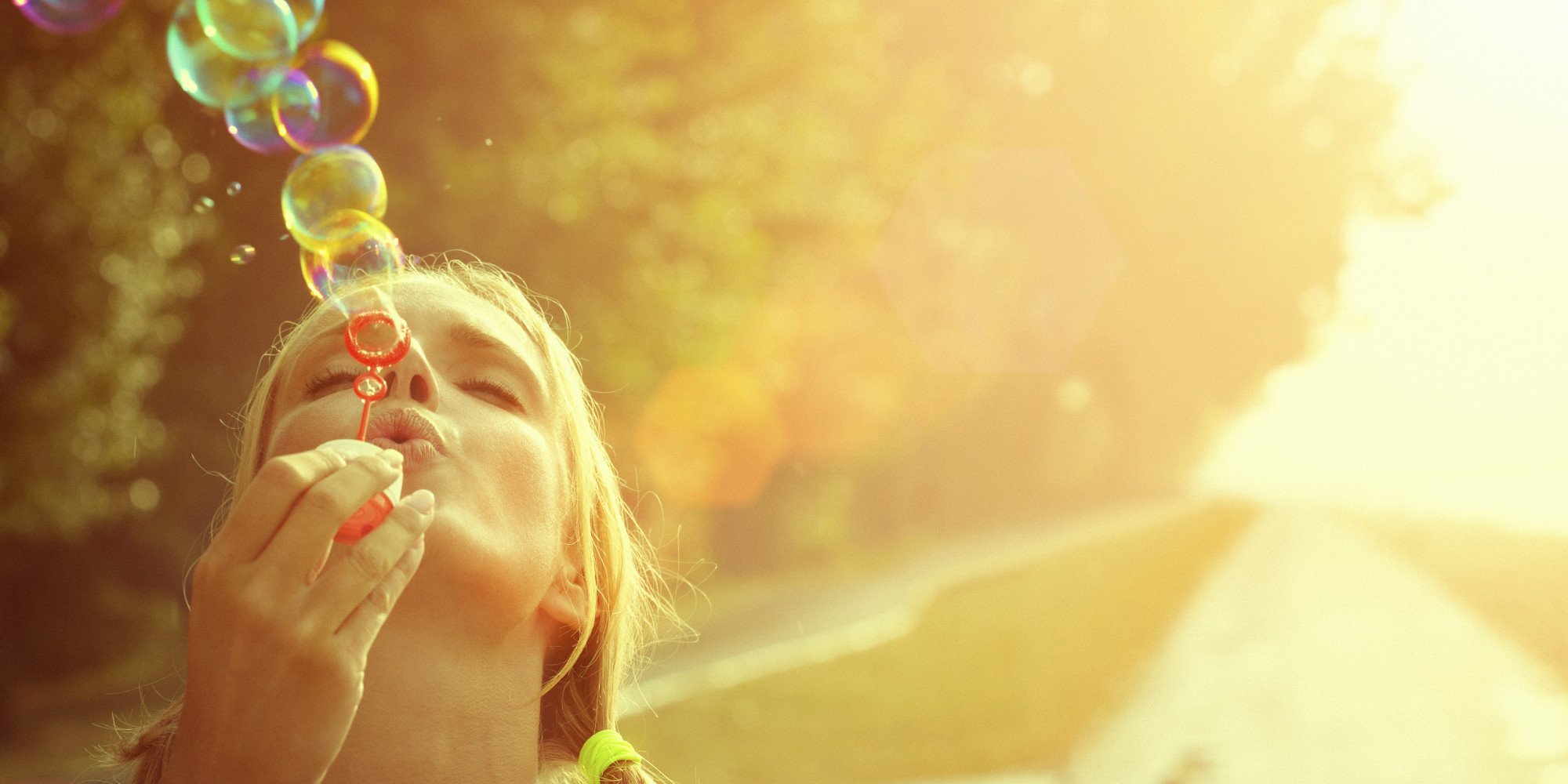 Young woman having fun and blowing bubbles outdoors